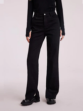 a lady in black straight leg jeans with black loafers